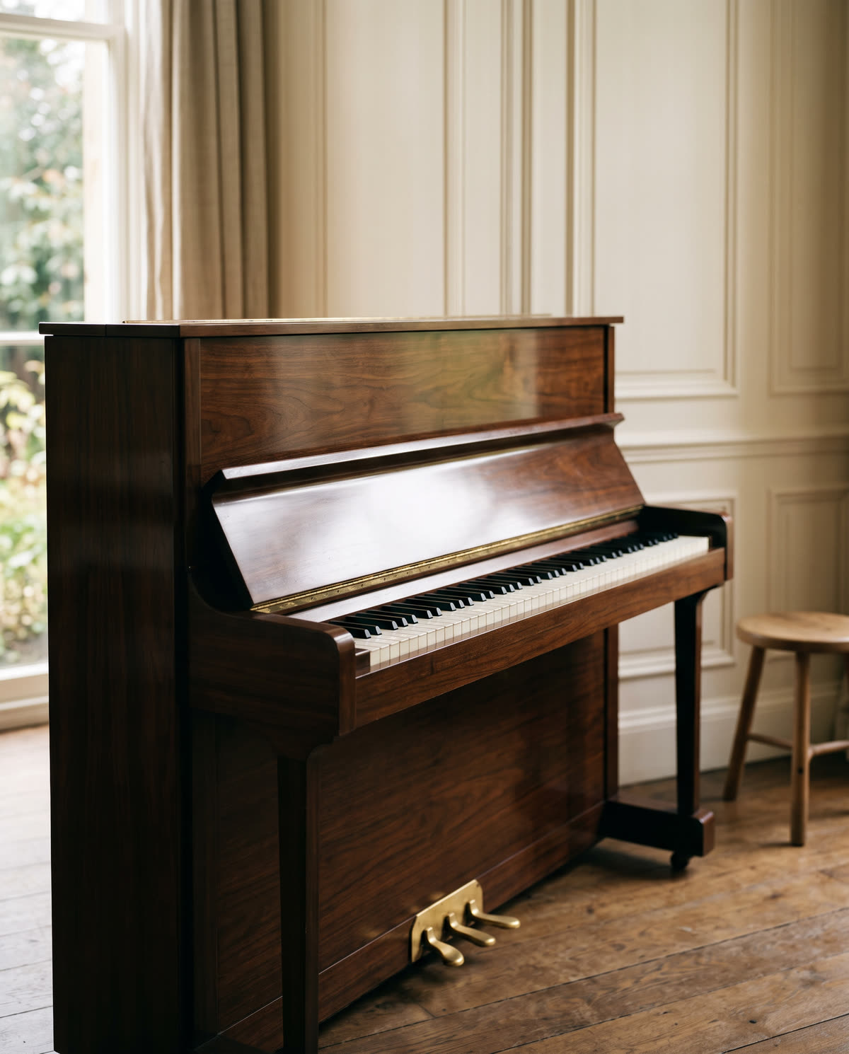 Un piano vertical junto a la ventana